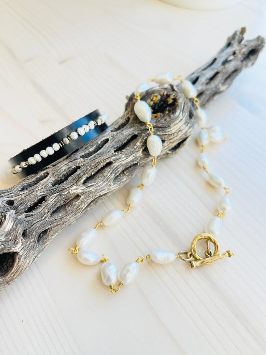 Pearl Choker displayed on driftwood with bracelet
