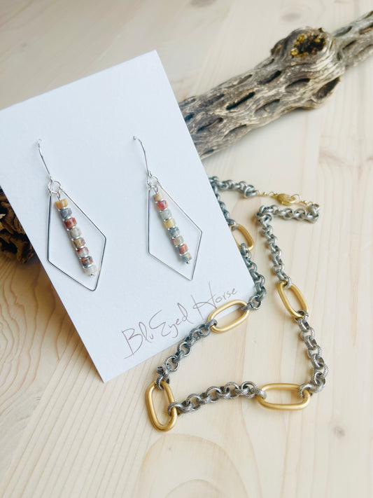 Lacy Earrings Made in the USA with necklace chain in front of driftwood on table