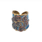 Handmade adjustable ring made of brass and copper with a swirl design and vintage denim patina coating.