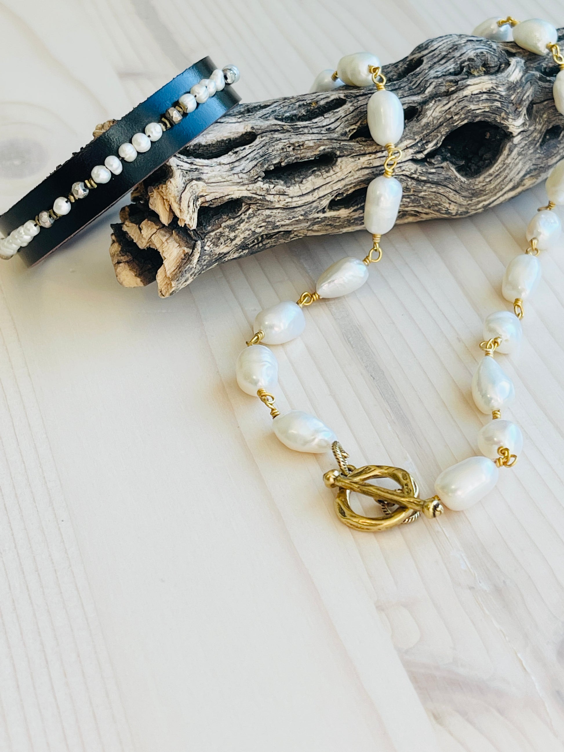 Pearl Choker displayed on driftwood with bracelet