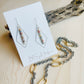 Lacy Earrings Made in the USA with necklace chain in front of driftwood on table