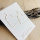 Gold Heart Earrings displayed on driftwood