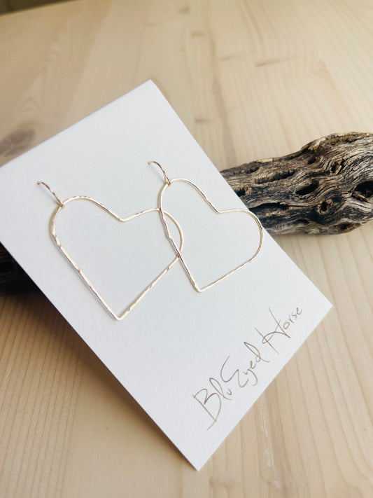 Gold Heart Earrings displayed on driftwood