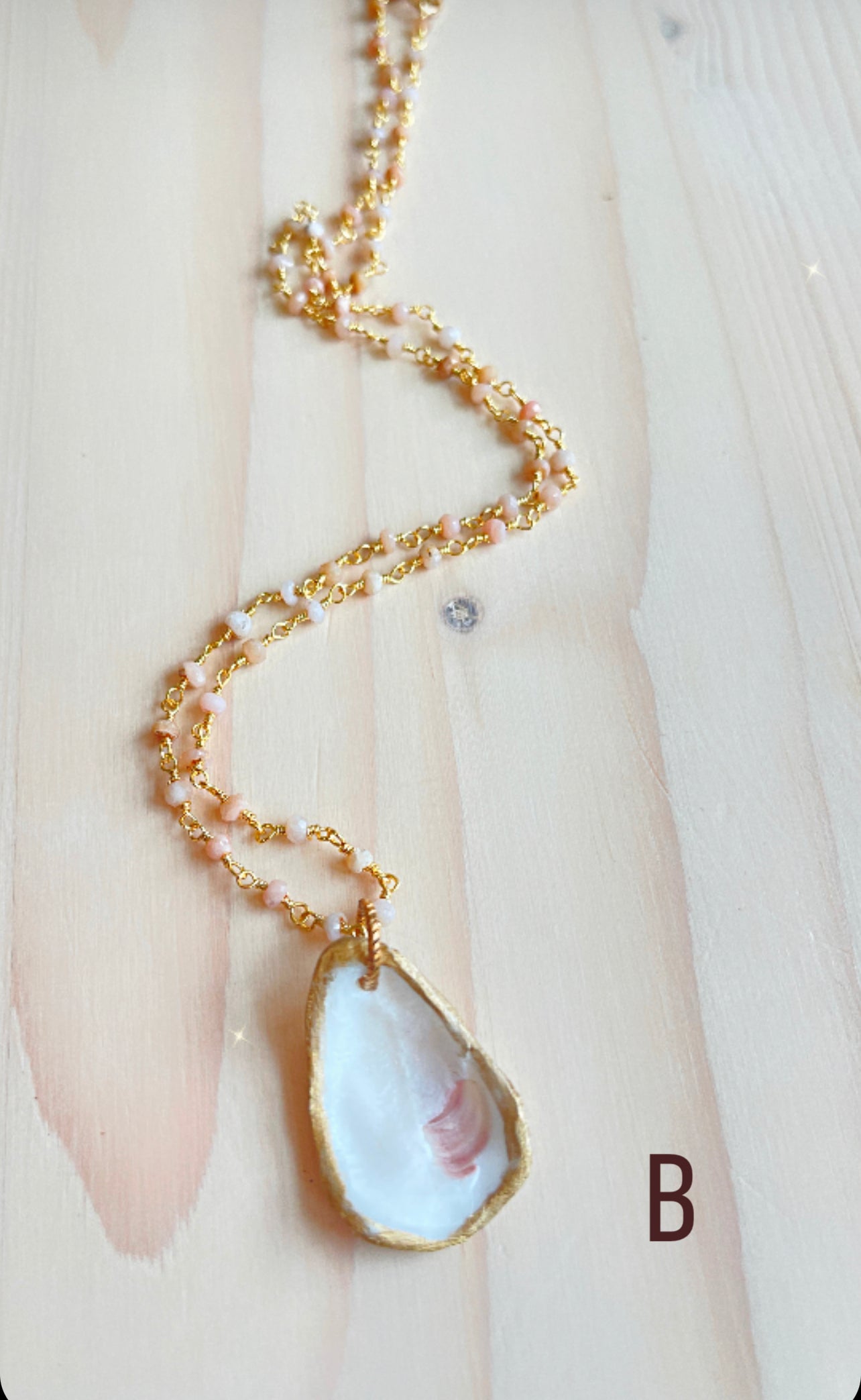 B.  Oyster shell with pink Opal gemstone beaded chain.
