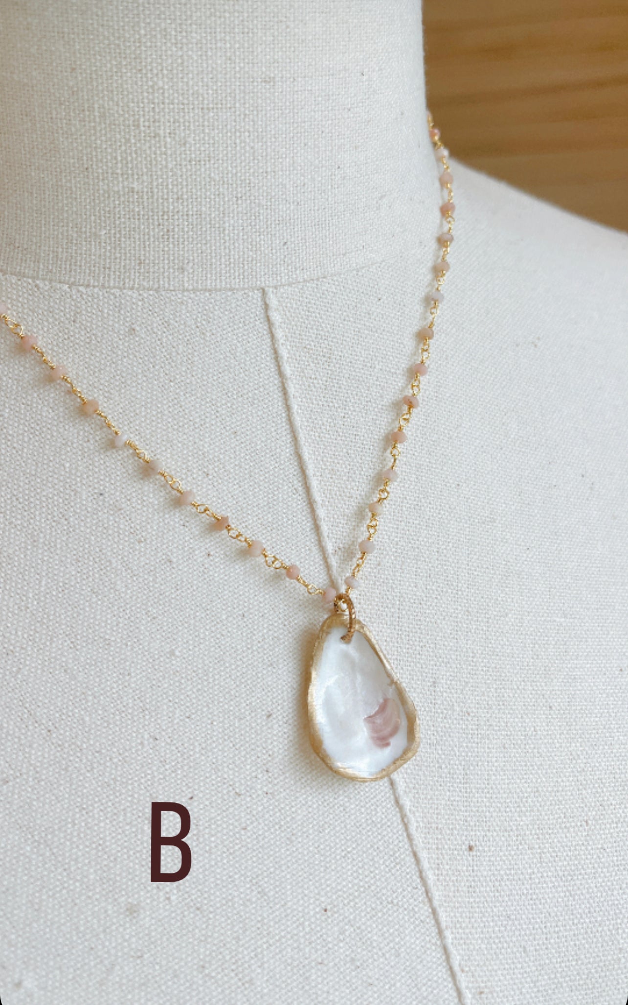 B.  Oyster shell with pink Opal gemstone beaded chain.