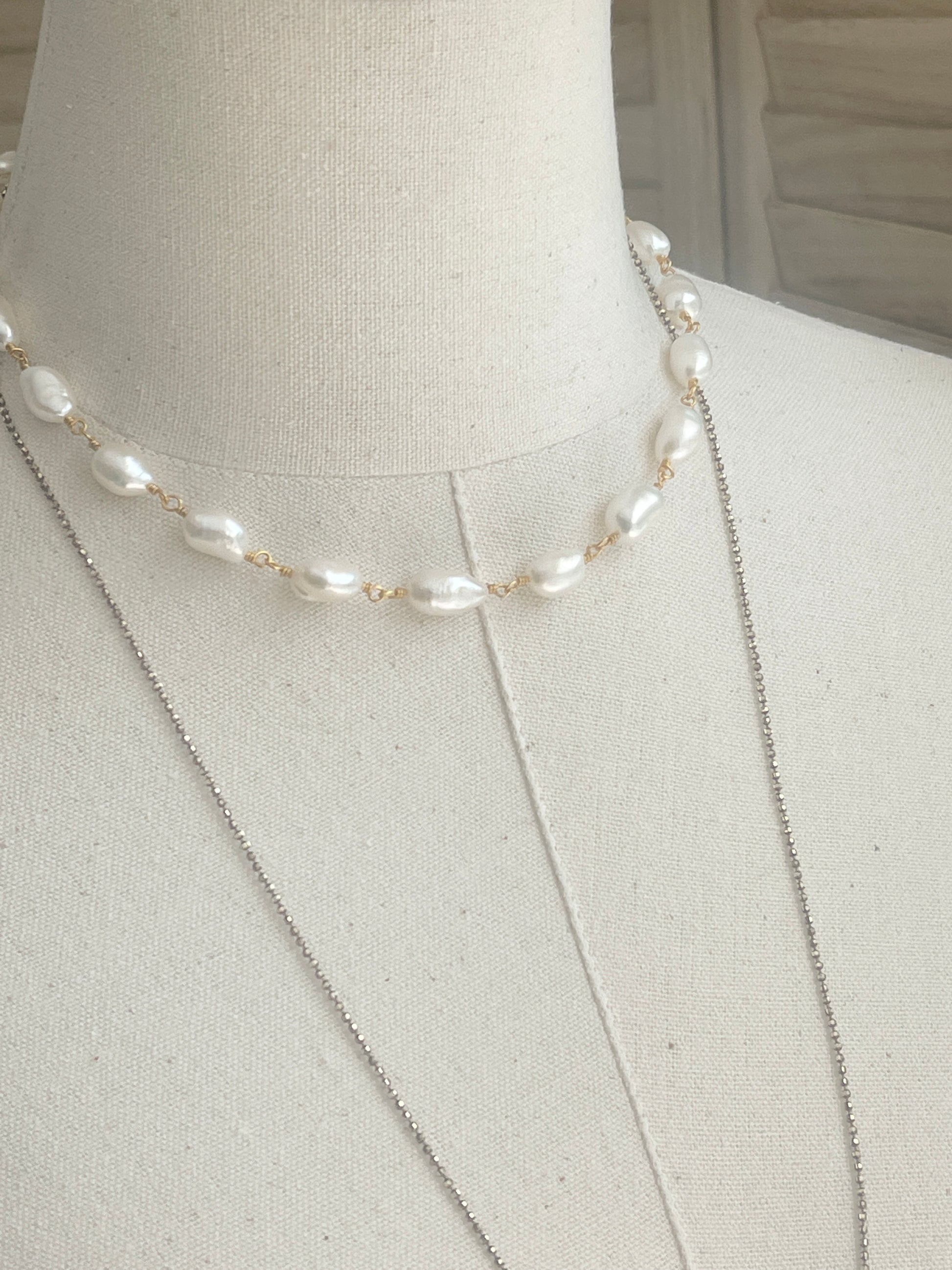 Pearl Choker displayed on driftwood with necklace on mannequin