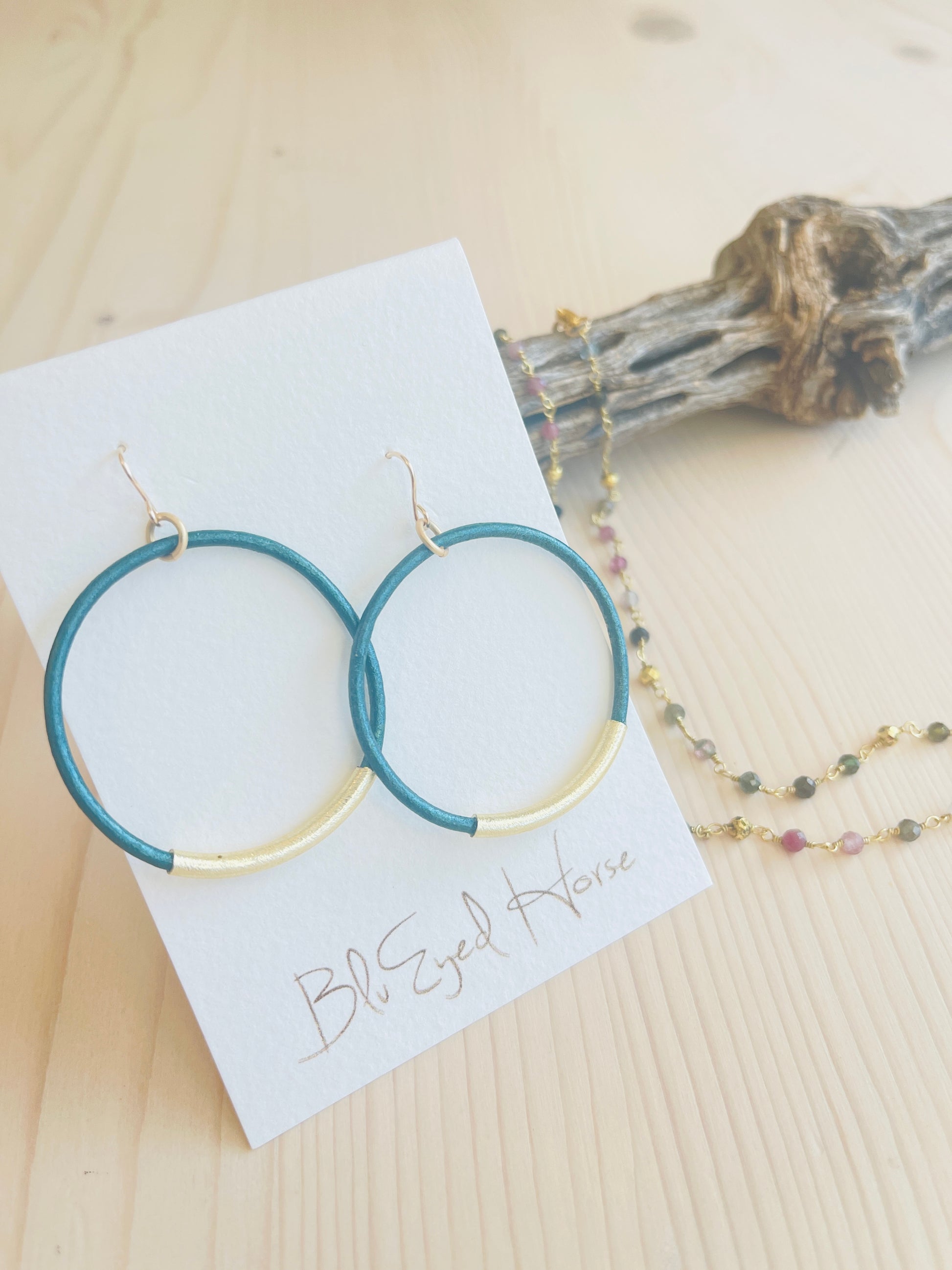 Teal Leather Hoops and multi colored stone necklace with driftwood in background