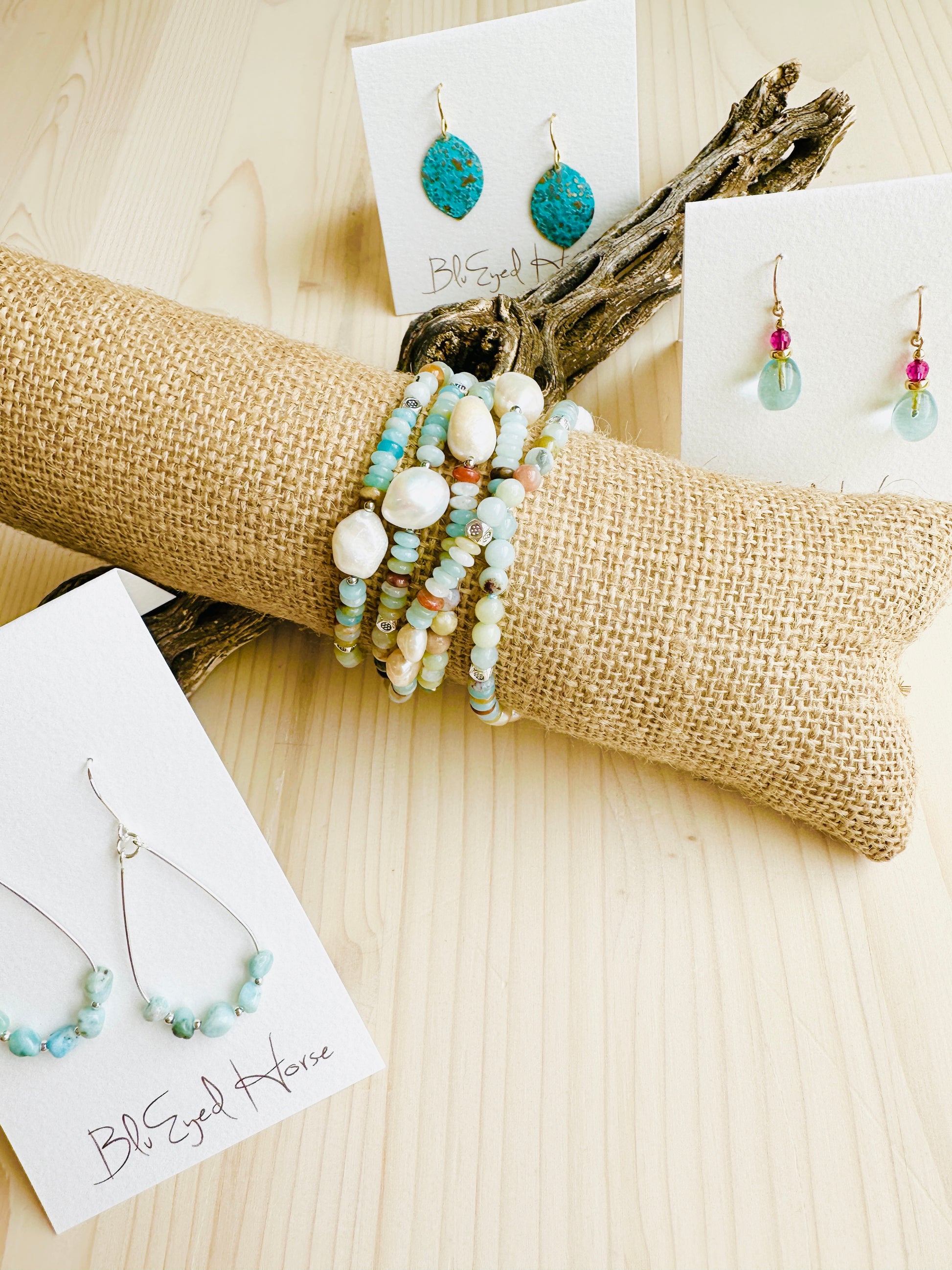 Green Cove Necklace displayed on canvas with multi tone earrings