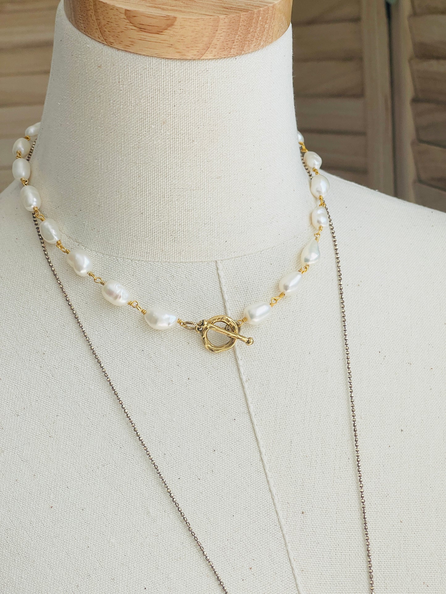 Pearl Choker displayed on driftwood with necklace on mannequin